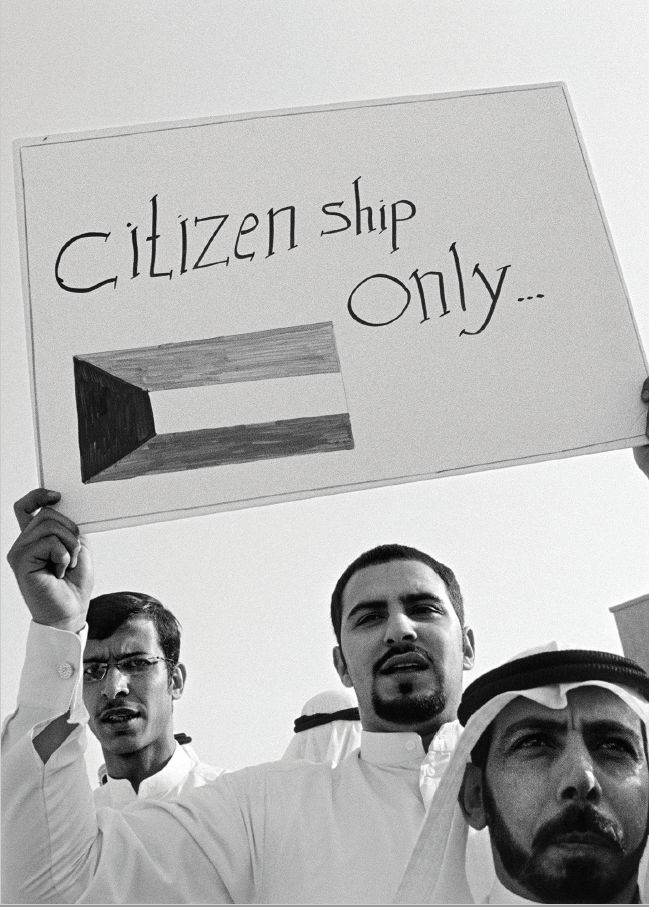 Bidoon men holding a 'Citizenship only' notice